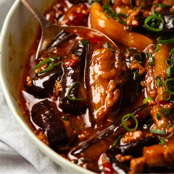 Stir-fried dish with eggplant and vegetables in a red sauce, served in a bowl.